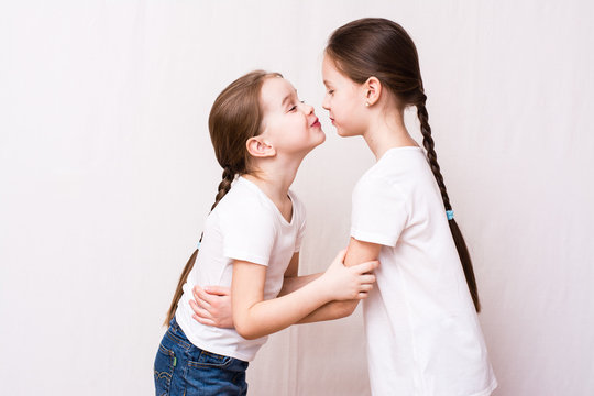 Two girls sisters kiss each other when meeting