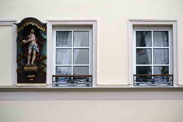 Eine Skulptur von Jesus hängt als Schutzpadron an dem Fenster eines Wohnhauses. ..