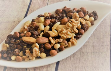 different peeled nuts and raisins on a white elegant plate