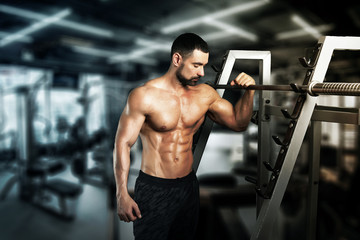 Fototapeta na wymiar muscular young man lifting weights in epic gym 