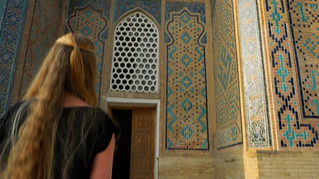 Young woman tourist touring mosque in Uzbekistan