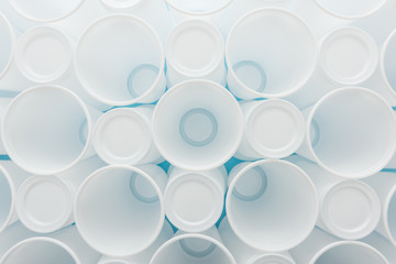 top view of white and plastic cups on blue background