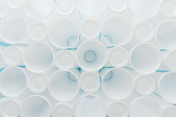 top view of white and plastic cups on blue background