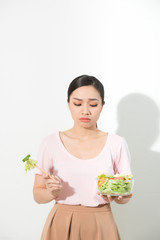 unhappy asian women is on dieting time. girl do not want to eat vegetables and dislike taste of vegetable.