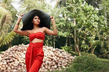 Summer fashion. Woman model in stylish clothes sun hat at nature