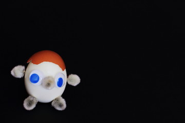 Good funny fabulous fictional character made from chicken eggs, chicken shells and willow buds on black background. Handmade. Minimal style.