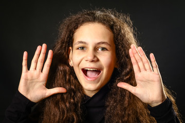 Emotional portrait of a girl with long curly hair on background