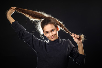 Emotional portrait of a girl with long curly hair on a black background,