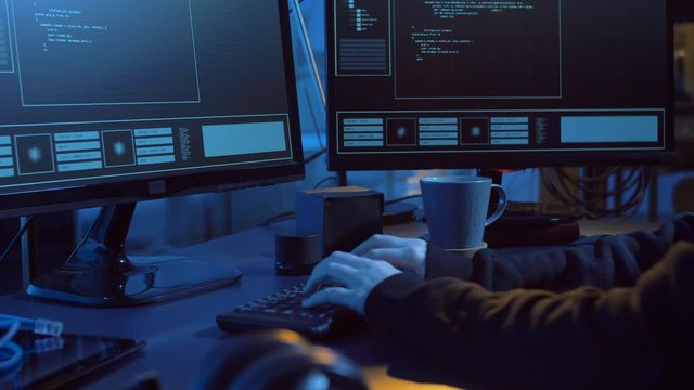 cybercrime, hacking and technology concept - female hacker in dark room creating code or using computer virus program for cyber attack