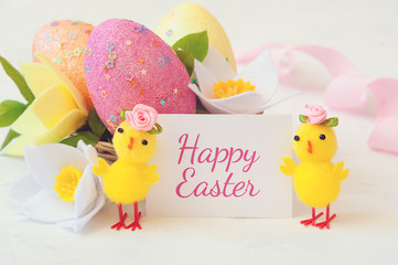 Easter egg, spring flowers and chickens on a white background and the inscription happy Easter . Festive Easter card