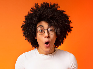Surprised and shocked curly african-american guy opened mouth