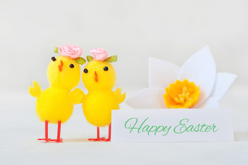 Two little yellow chicken with a congratulatory inscription - happy easter.