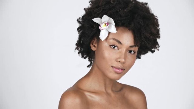 nude curly african american girl smiling while looking at camera on white 