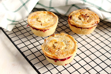 Traditional rustic homemade american  mini cherry pie with golden crust on cooling rack
