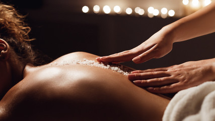 Salt scrub massage. Woman relaxing in health spa