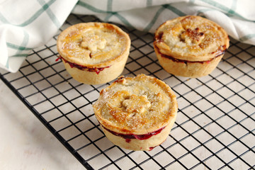 Traditional rustic homemade american  mini cherry pie with golden crust on cooling rack