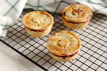 Traditional rustic homemade american  mini cherry pie with golden crust on cooling rack