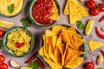 Mexican food background: guacamole, salsa, cheesy sauces with nachos