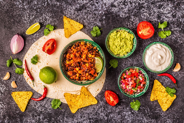 Mexican food concept: tortillas, nachos with guacamole, salsa.