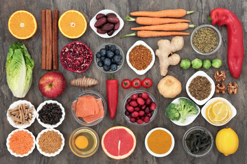 Healthy food to slow the ageing process concept including fruit, vegetables, fish, seeds, nuts, herbs, spices and pollen grain. Very high in antioxidants, anthocyanins, dietary fibre and vitamins. 