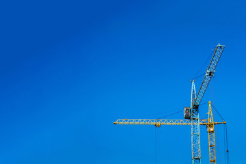 Two cranes against the blue sky.