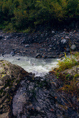 Caucasian Mountain River in the woods in the morning at dawn when the first rays of the sun make their way into the valley between the mountains in the surroundings of Dombai.