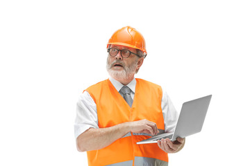 The builder in a construction vest and an orange helmet with laptop. Safety specialist, engineer, industry, architecture, manager, occupation, businessman, job concept
