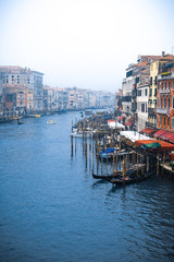 Fototapeta na wymiar Venice / Italy 19 february 2019 :view of the Canal in Venice from Rialto bridge,gondolas are crossing the river and people enjoy their winter vacations