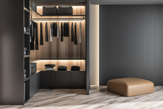 Modern wooden wardrobe with clothes hanging on rail in walk in closet design interior. 3D render