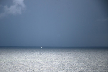 Small white sailing yacht on horizon in Gulf of Finland, Baltic sea