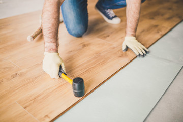 Adult man lays the laminate panel on the substrate with the technology