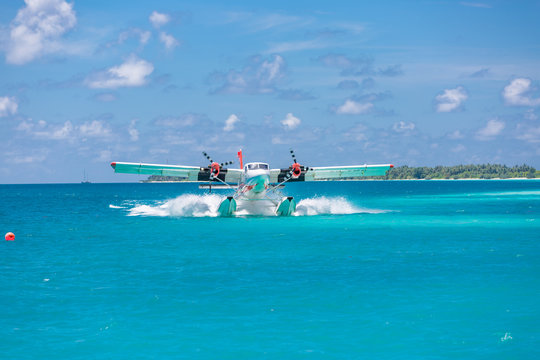 Exotic scene with seaplane on Maldives sea landing. Vacation or holiday in Maldives concept background