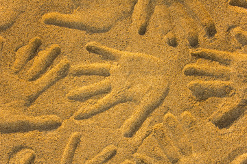 hand prints in yellow sand close up