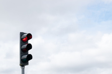 Red Traffic stop light with cloudy background