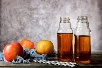 On the table is apple juice in a glass bottle