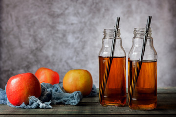On the table is apple juice in a glass bottle