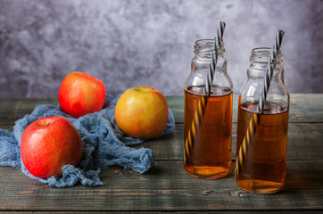 On the table is apple juice in a glass bottle