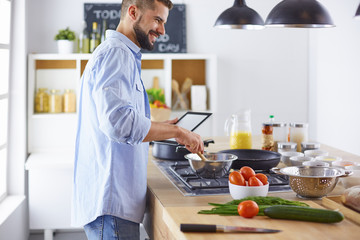 Smiling and confident chef standing in large kitchen