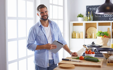 Smiling and confident chef standing in large kitchen