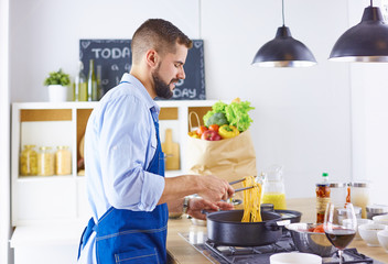 Smiling and confident chef standing in large kitchen