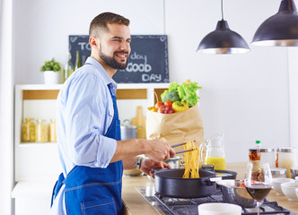 Smiling and confident chef standing in large kitchen