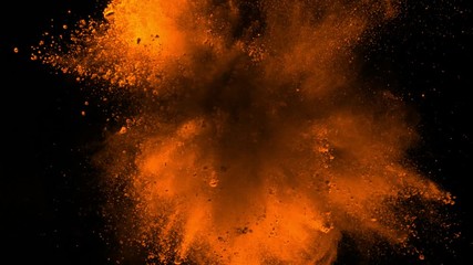 Super slowmotion shot of golden powder explosion isolated on black background.
