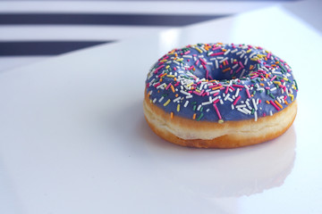 sweet Donut with icing and color dusting, on a white background, side view