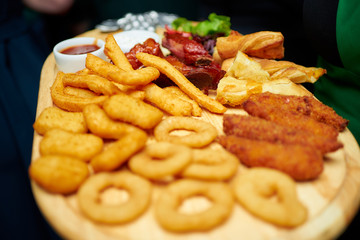 A lot of roasted snacks on a wooden plate.