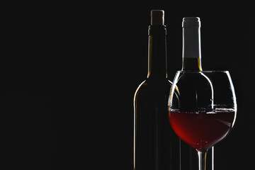  wine bottle and wine glass in a black background