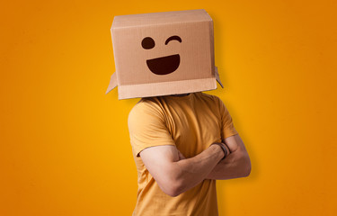 Funny man wearing cardboard box on his head with smiley face
