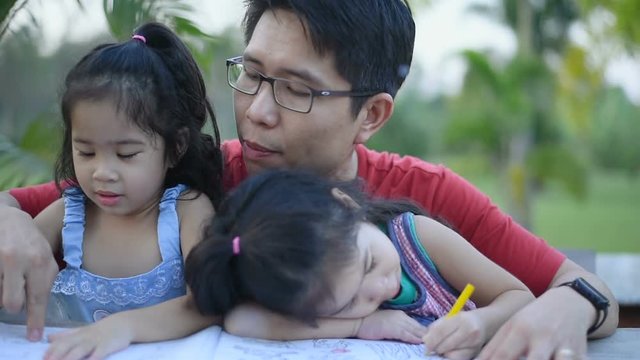 Happy dad with twins daughter painting together, loving father enjoying leisure with daughter