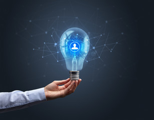 Hand holding light bulb on dark background. Networking idea concept