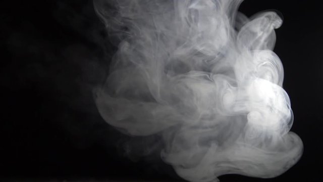 white smoke moves on a black background and slowly disappears