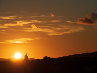 silhouette of lighthouse with red orange sky when sunset